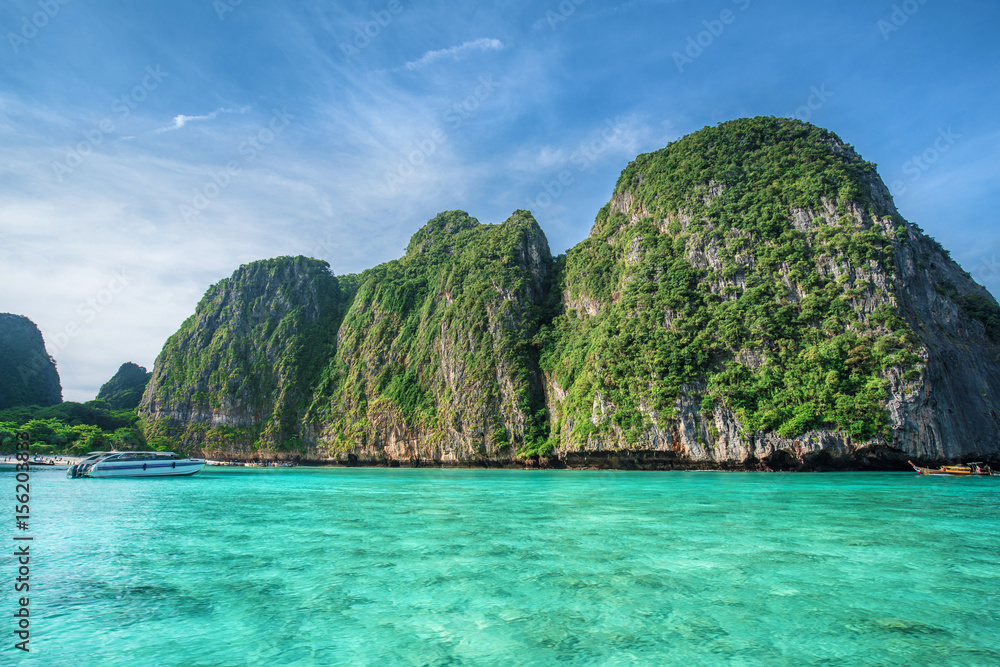 Tropical landscape with rock islands, lonely boat and crystal clear at Phi Phi island