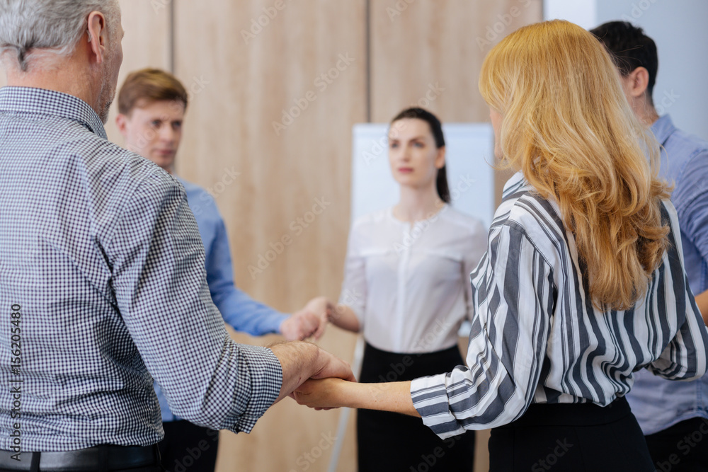 Obraz premium Nice serious people holding hands