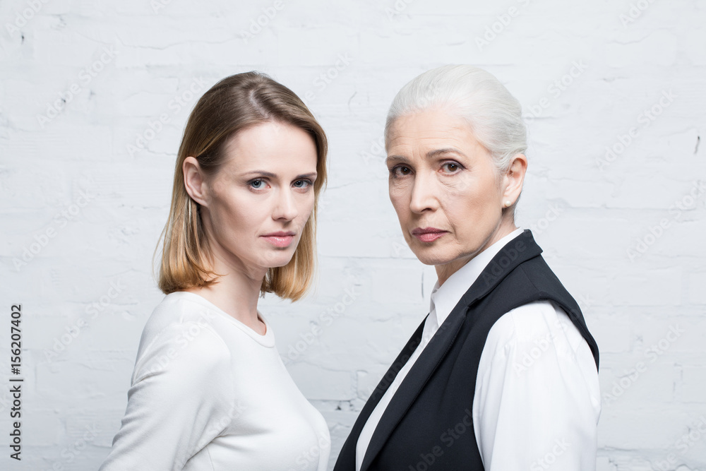 Portrait of serious women standing together and looking at camera, young and senior people Portrait of serious women standing together and looking at camera, young and senior people