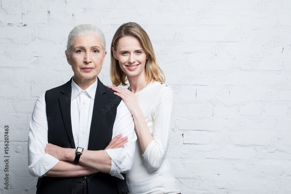 Portrait of beautiful smiling women standing together, young and senior people Portrait of beautiful smiling women standing together, young and senior people