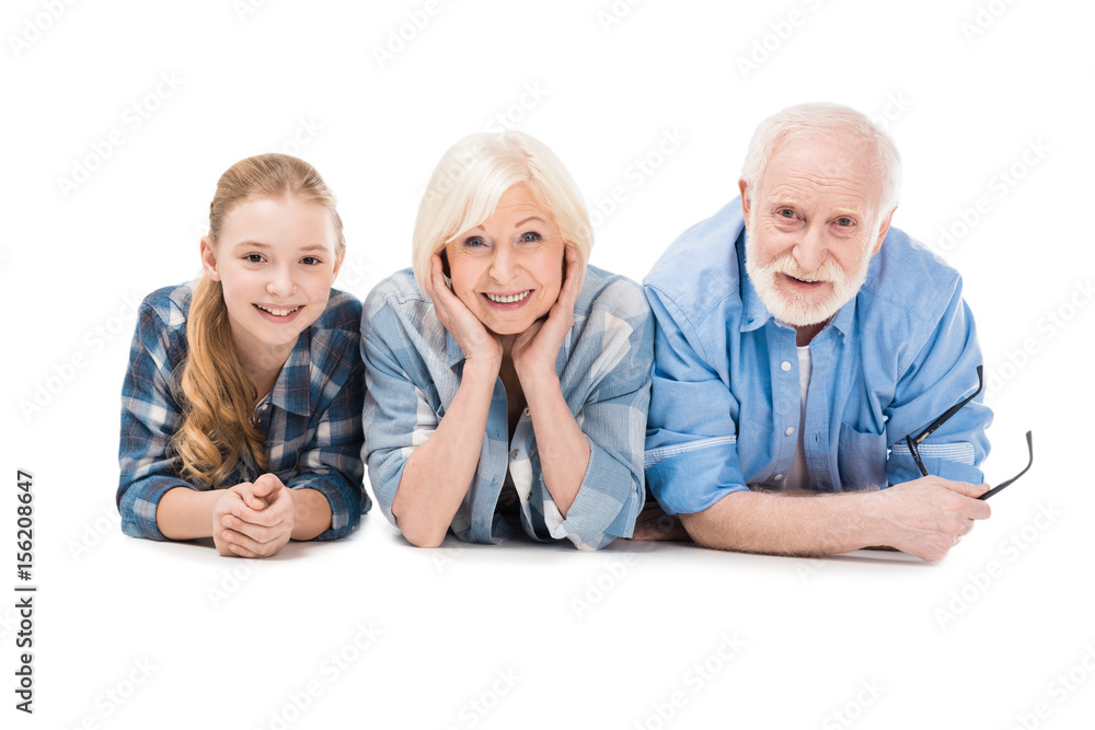 grandfather, grandmother and granddaughter lying together isolated on white