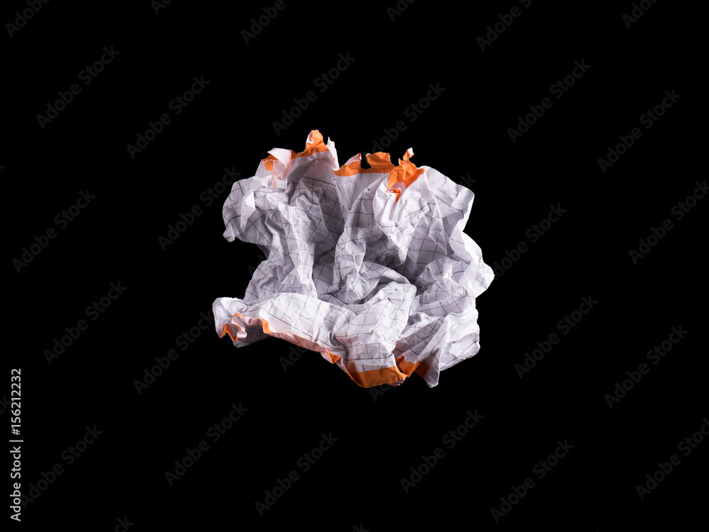 Crumpled piece of white blank squared paper exercise book on black background.