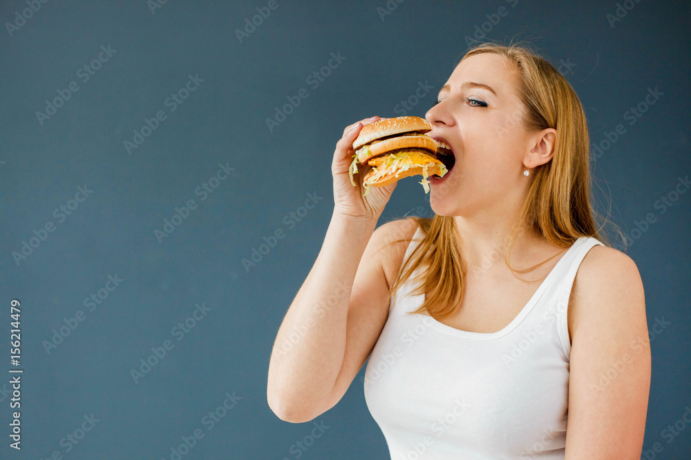Woman with obesity holds hamburger in her hand Woman with obesity holds hamburger in her hand
