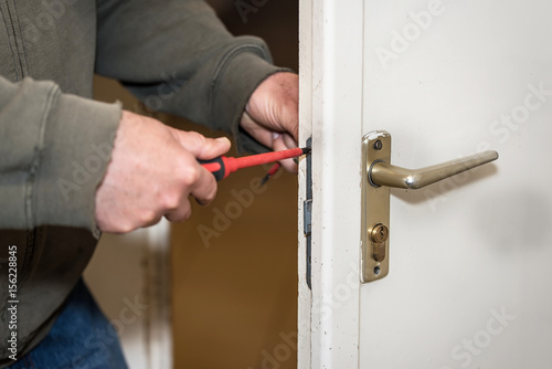 Male handyman worker wood door lock installation or repairing