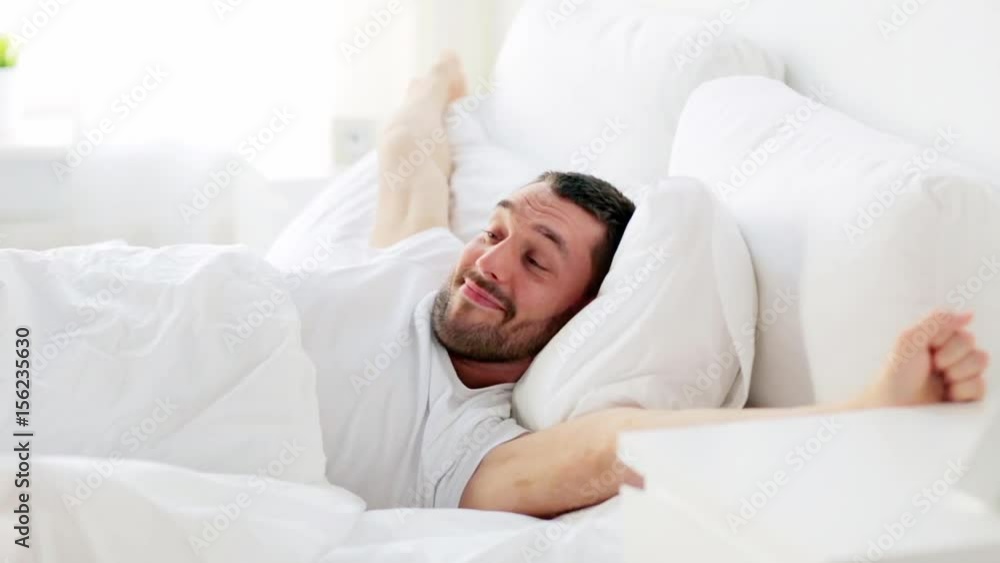 man waking up in bed at home man waking up in bed at home