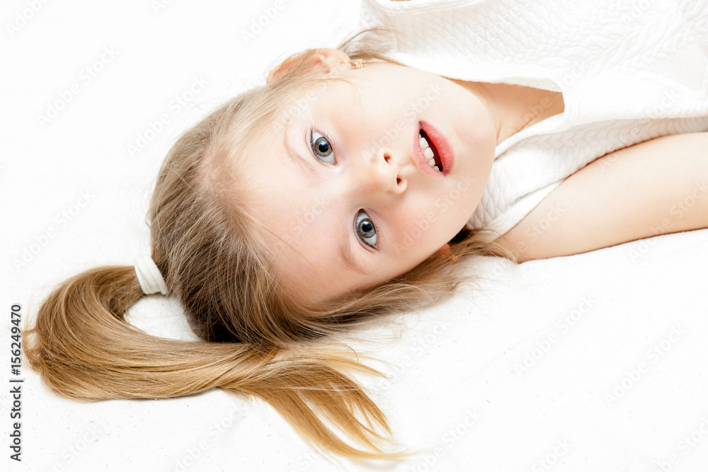Pretty little blonde girl summer white dress lying on the floor and ...