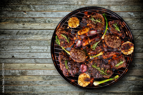 Top view of fresh meat and vegetable on grill placed on wooden floor
