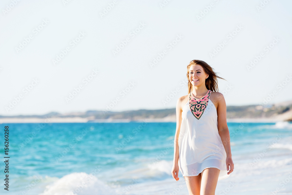 Young woman walking along the beach Young woman walking along the beach