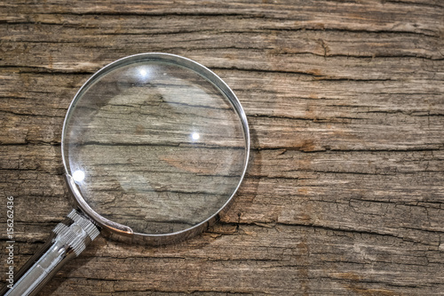 Magnifier on the wooden table with copy space
