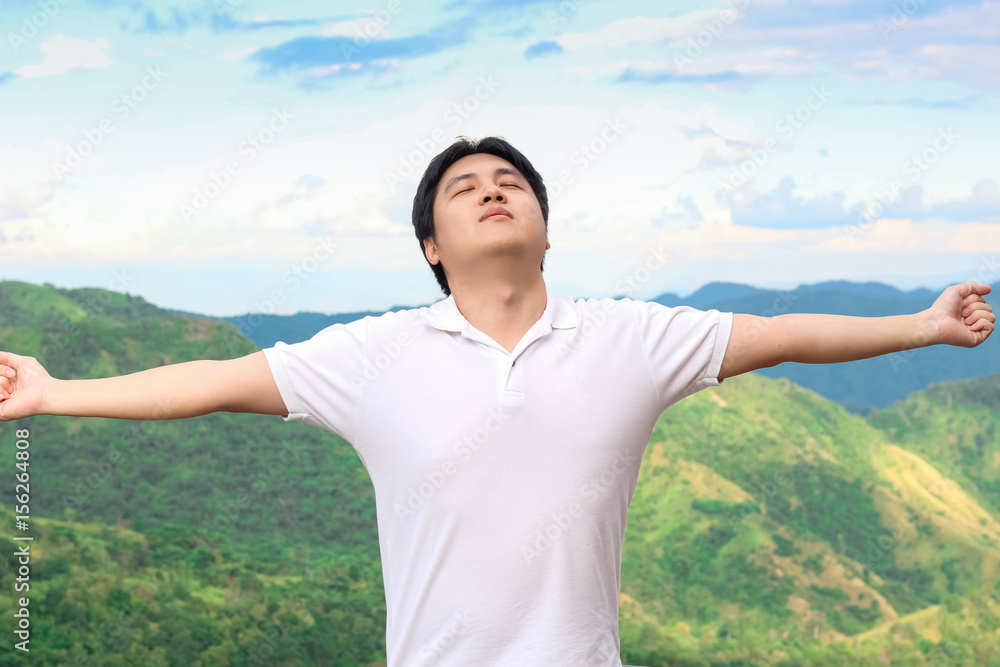 Asian man is taking deep breath in the nature environment Asian man is taking deep breath in the nature environment