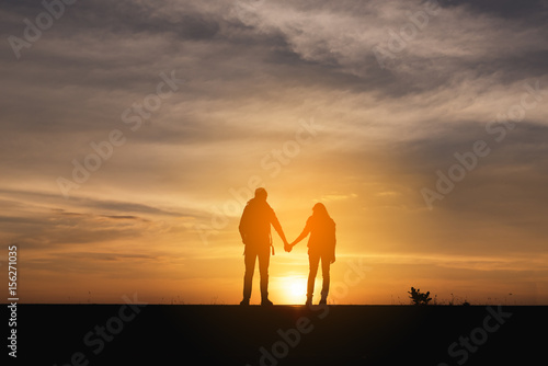 Silhouette of the Couple walking on the road near the sea. Family travel and healthy lifestyle concept.