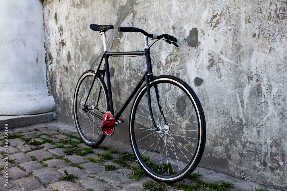 black hipster bicycle near the grey concrete wall black hipster bicycle near the grey concrete wall