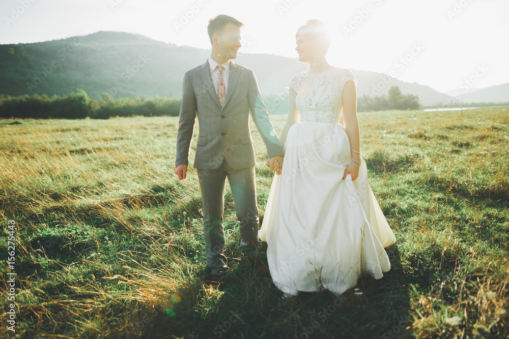 Beautiful wedding couple, love on the sunset. Fielf with view on mountains