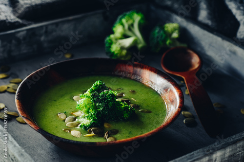 Broccoli cream soup with pumpkin seeds. Dark  wooden background
