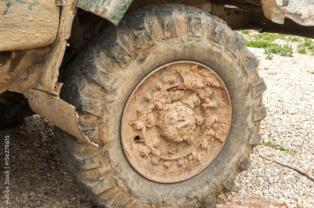 Muddy grunge tyre wheel of heavy duty truck closeup