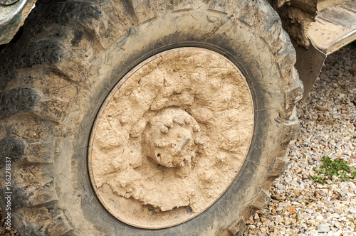 Muddy grunge tyre wheel of heavy duty truck closeup