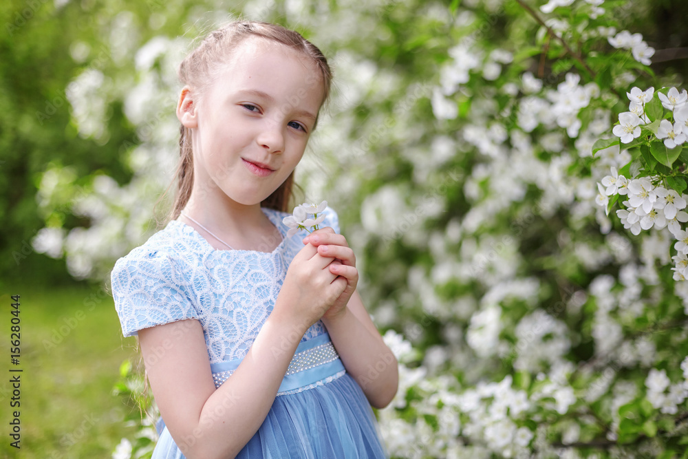 Cute little girl in blooming apple tree garden at spring Cute little girl in blooming apple tree garden at spring