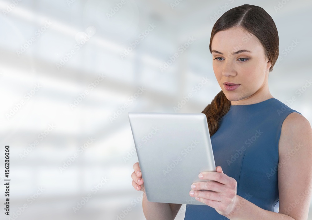 Fototapeta premium Businesswoman holding tablet in bright space hall