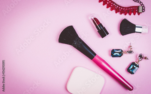 Fototapeta Naklejka Na Ścianę i Meble -  Various makeup cosmetics, brushes, necklace and other essentials on pink background top view. Pink beauty cosmetics for background concept.