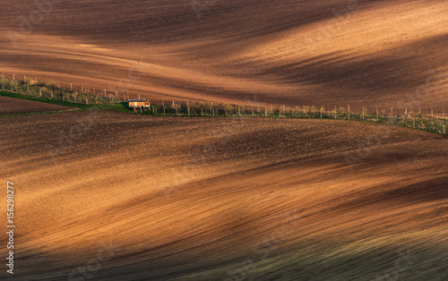 Fairytale Minimalistic Agricultural Autumn Landscape With Small Apiary On Cultivated Field. Beautiful Wavy  Broun Texture Fields With Amazing Stripe Patterns In Springtime.   Rural Scenic Landscape  © Vlad Sokolovsky