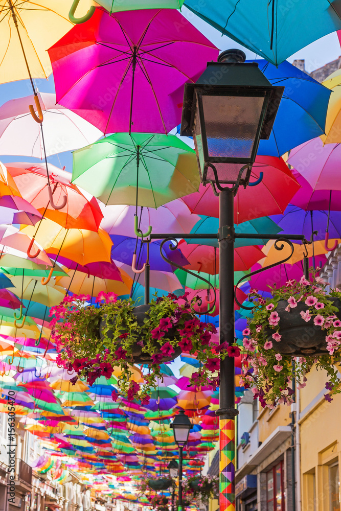 The sky of colorful umbrellas.Street with umbrellas.Umbrella Sky Project in  Agueda, Aveiro district, Portugal.Street decoration. Street decorated with  colored umbrellas. Stock-Foto | Adobe Stock