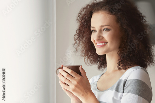 Young woman holding cup of ...