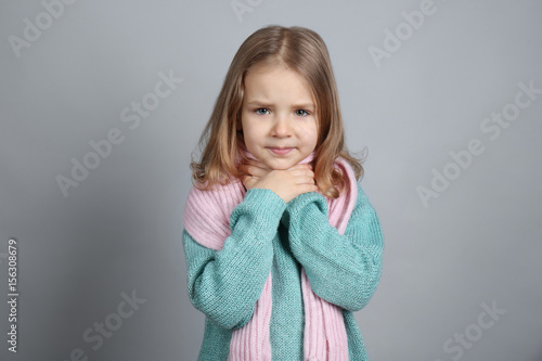 Bilde på lerret Little ill girl with sore throat on color background