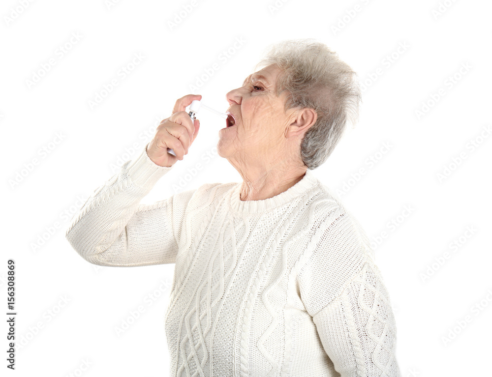 Senior ill woman using spray, isolated on white. Concept of allergy Senior ill woman using spray, isolated on white. Concept of allergy