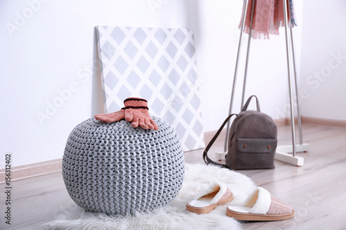 Fotografia Knitted pouf with clothes in modern hall interior
