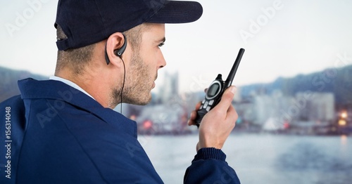 Tableau sur toile Security guard with cap and walkie talkie against blurry skyline