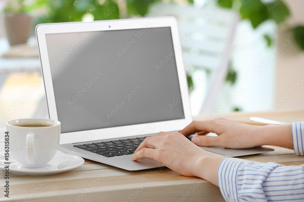 Woman working on laptop at table Woman working on laptop at table