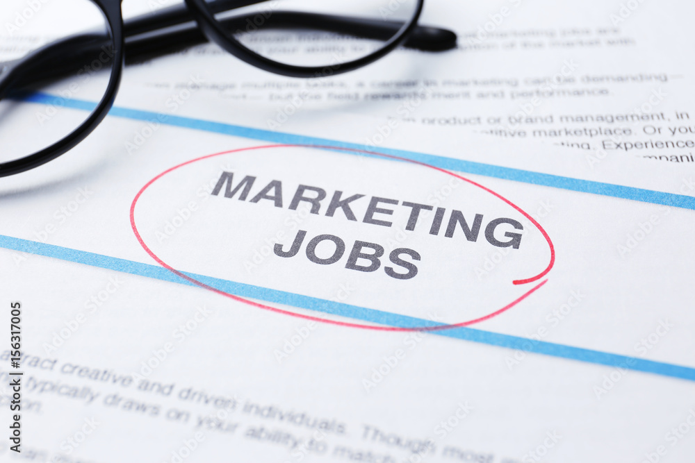 Paper sheet with text MARKETING JOBS, closeup Paper sheet with text MARKETING JOBS, closeup