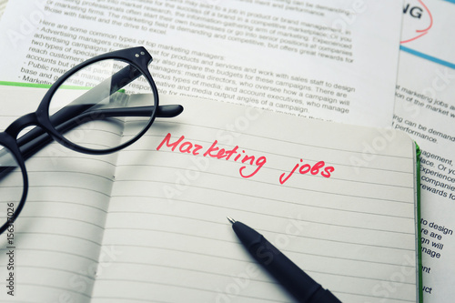 Open notebook with text MARKETING JOBS, closeup