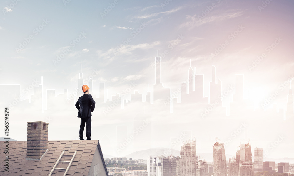 Engineer man standing on roof and looking away. Mixed media Engineer man standing on roof and looking away. Mixed media