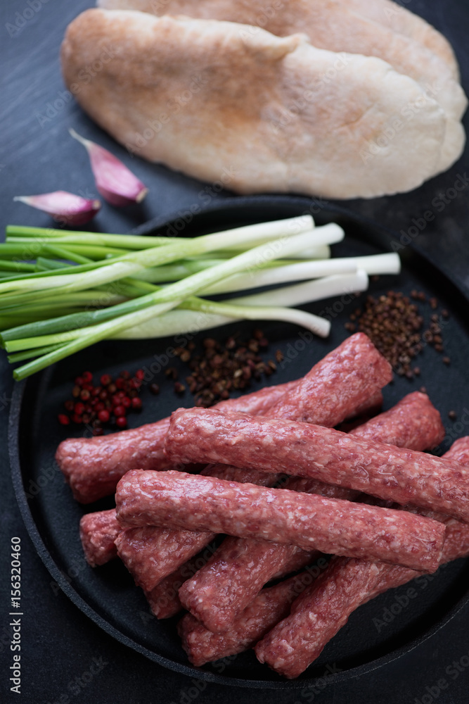 Close-up of raw balkan traditional cevapi ready to be cooked, vertical shot