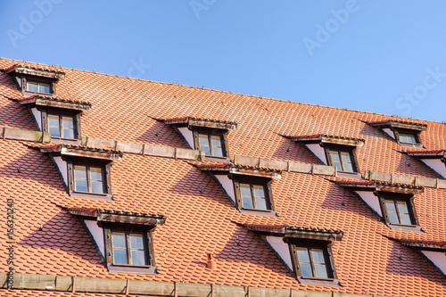 Tiled roof with mansard windows of attic rooms