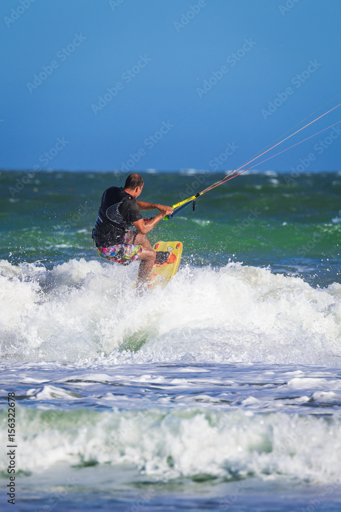 Young atletic man riding kite surf on a sea