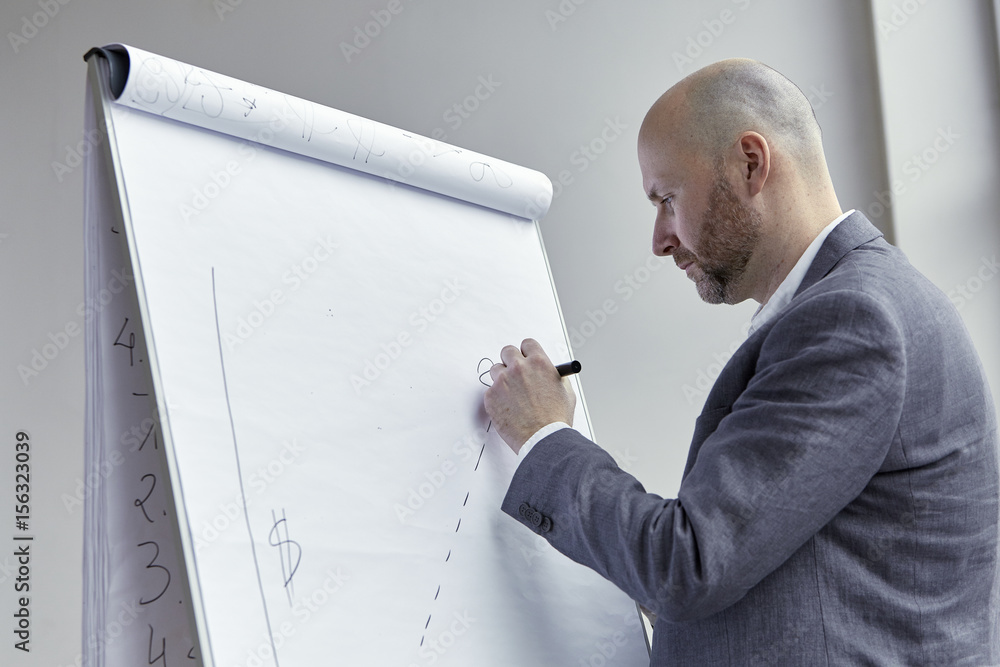 Bald Businessman Drawing a Punctuated Line on the Board