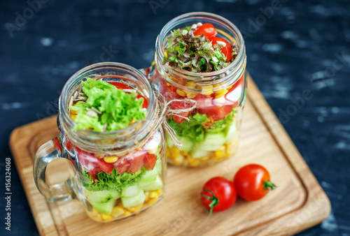 Salad with tomatoes and cucumbers and corn in a glass jar. Healthy food, Diet, Detox, Clean Eating or Vegetarian concept