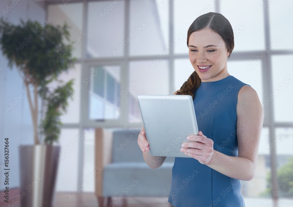 Businesswoman holding tablet in office by window Businesswoman holding tablet in office by window