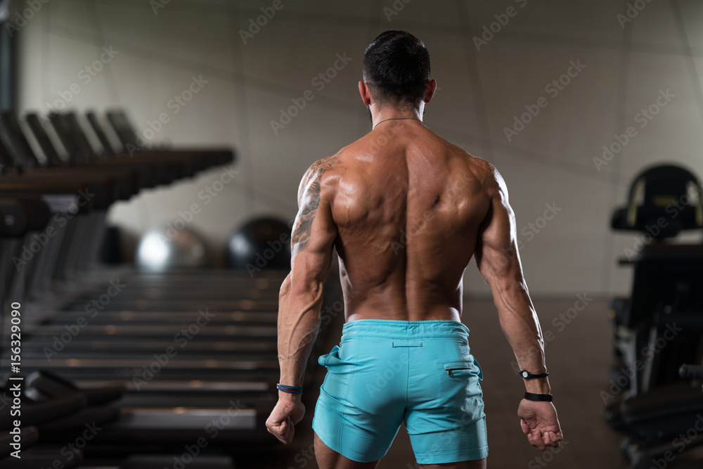 Muscular Man Flexing Back Muscles Pose Stock Photo | Adobe Stock