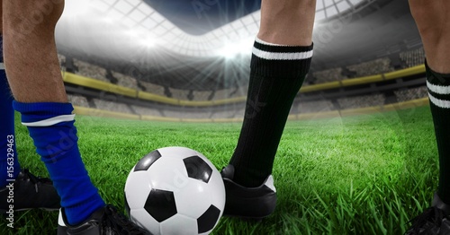 soccer players foots with ball in the field