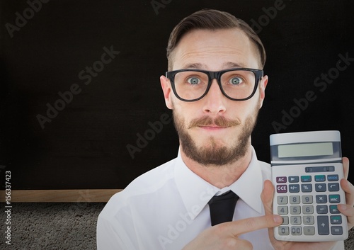 Man with calculator against blackboard