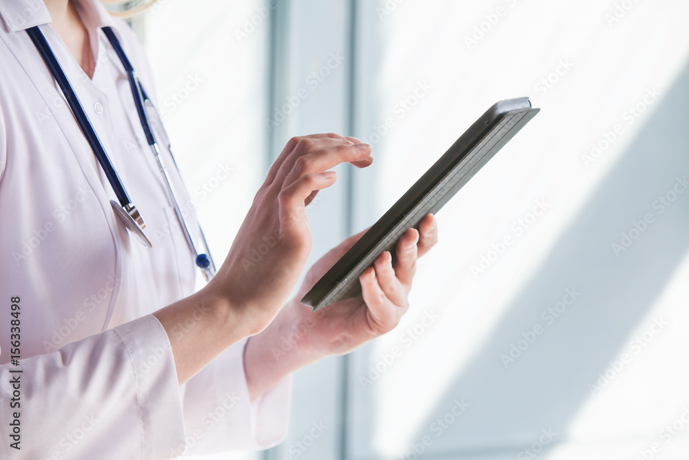 Female doctor working on tablet computer Female doctor working on tablet computer