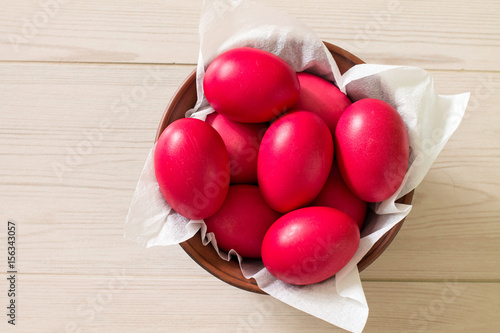 Wallpaper Mural Ceramic bowl with red Easter eggs on wooden background. Aerial view. Torontodigital.ca