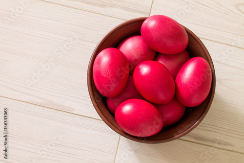 Wallpaper Mural Ceramic bowl with red Easter eggs on wooden background. Aerial view. Torontodigital.ca