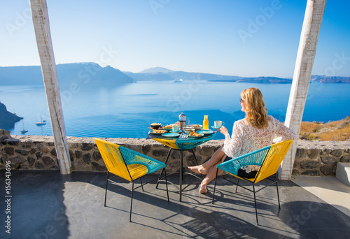 Woman enjoying breakfast with beautiful view from terrace