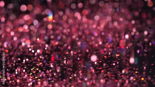 Red fashion glitter falling on the black background, abstract slow motion