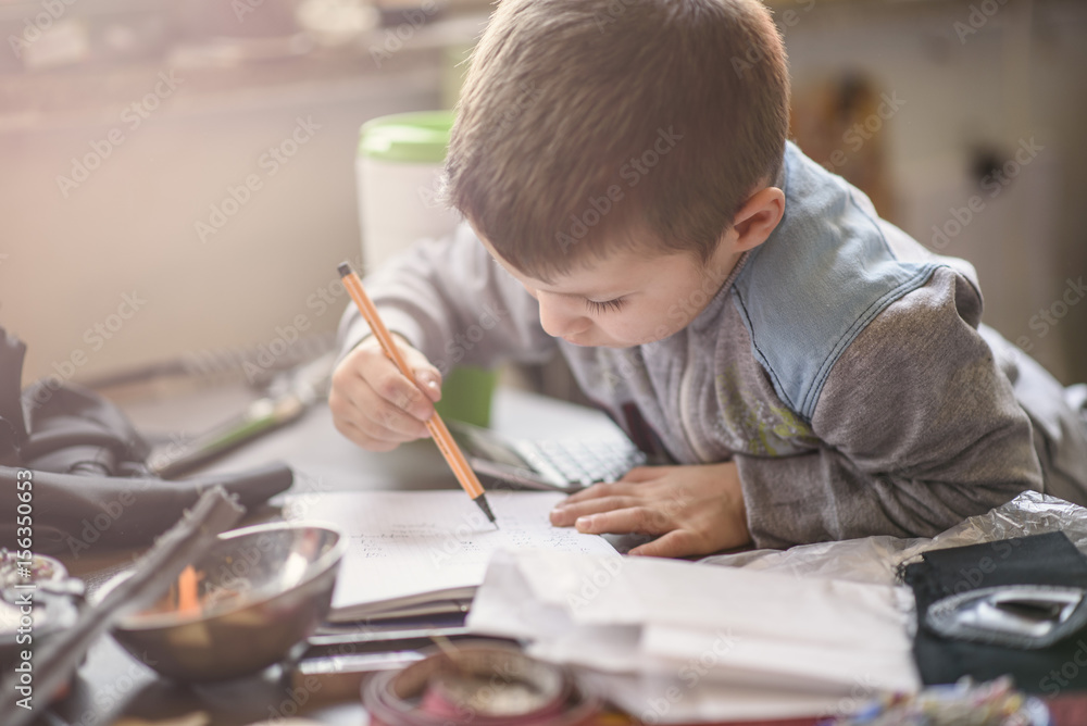 Cute little toddler boy writing words on a piece of paper with a pen Cute little toddler boy writing words on a piece of paper with a pen