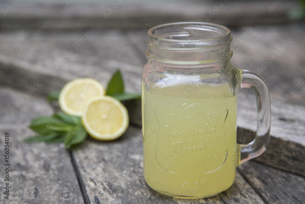 Lemon juice in jar, decorated with fresh lemons and mint leaves. Lemon juice in jar, decorated with fresh lemons and mint leaves.
